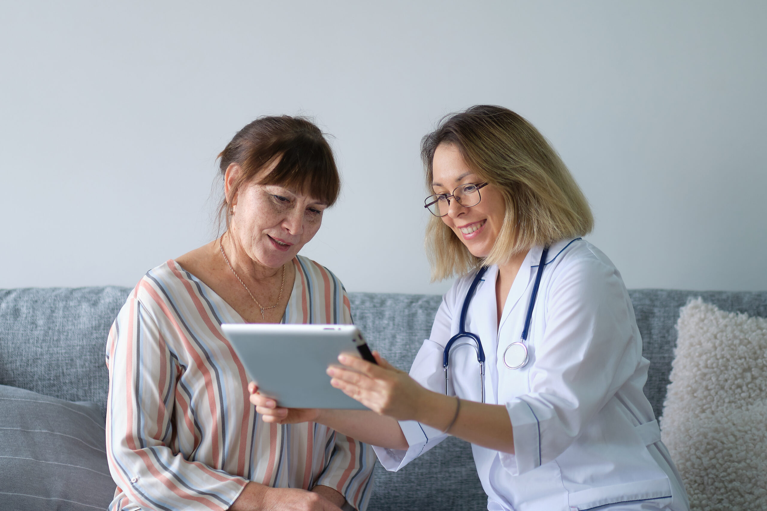 Electronic health records being used by healthcare worker with patient